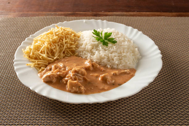 Chicken stroganoff accompanied with rice, salad and potato straw.