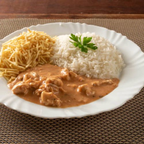 Chicken stroganoff accompanied with rice, salad and potato straw.